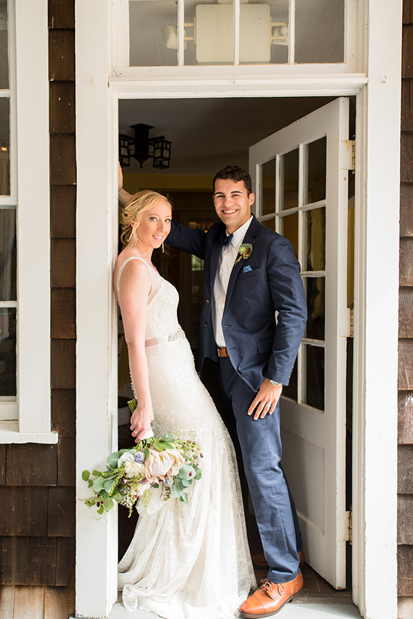 bride and groom leaning against a doorway