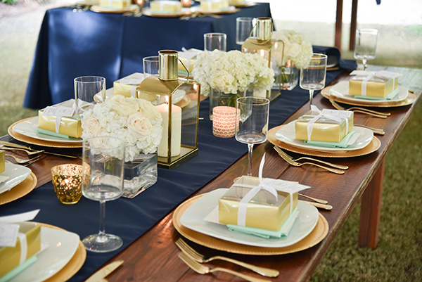 tablescape with navy blue and gold accents and white hydrangea bouquets
