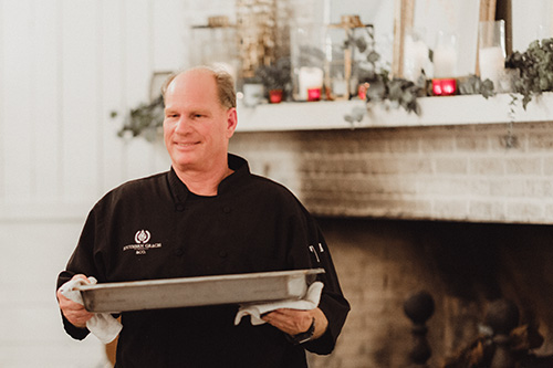 Chef Christopher Hewitt carrying a tray of food