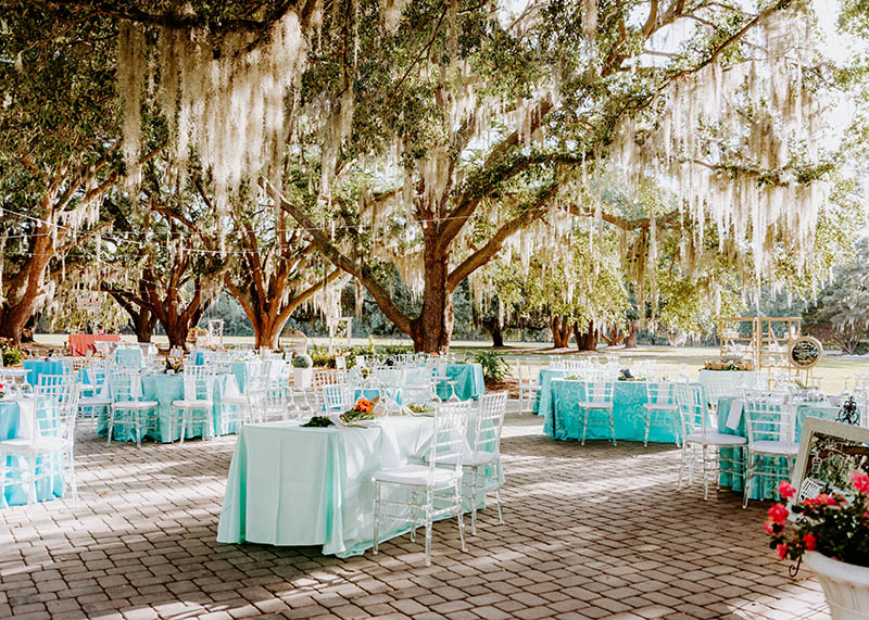 Tables set for an event in Riders Courtyard surrounded by beautiful live oaks