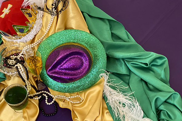 purple, green, and yellow mardi gras beads and hats